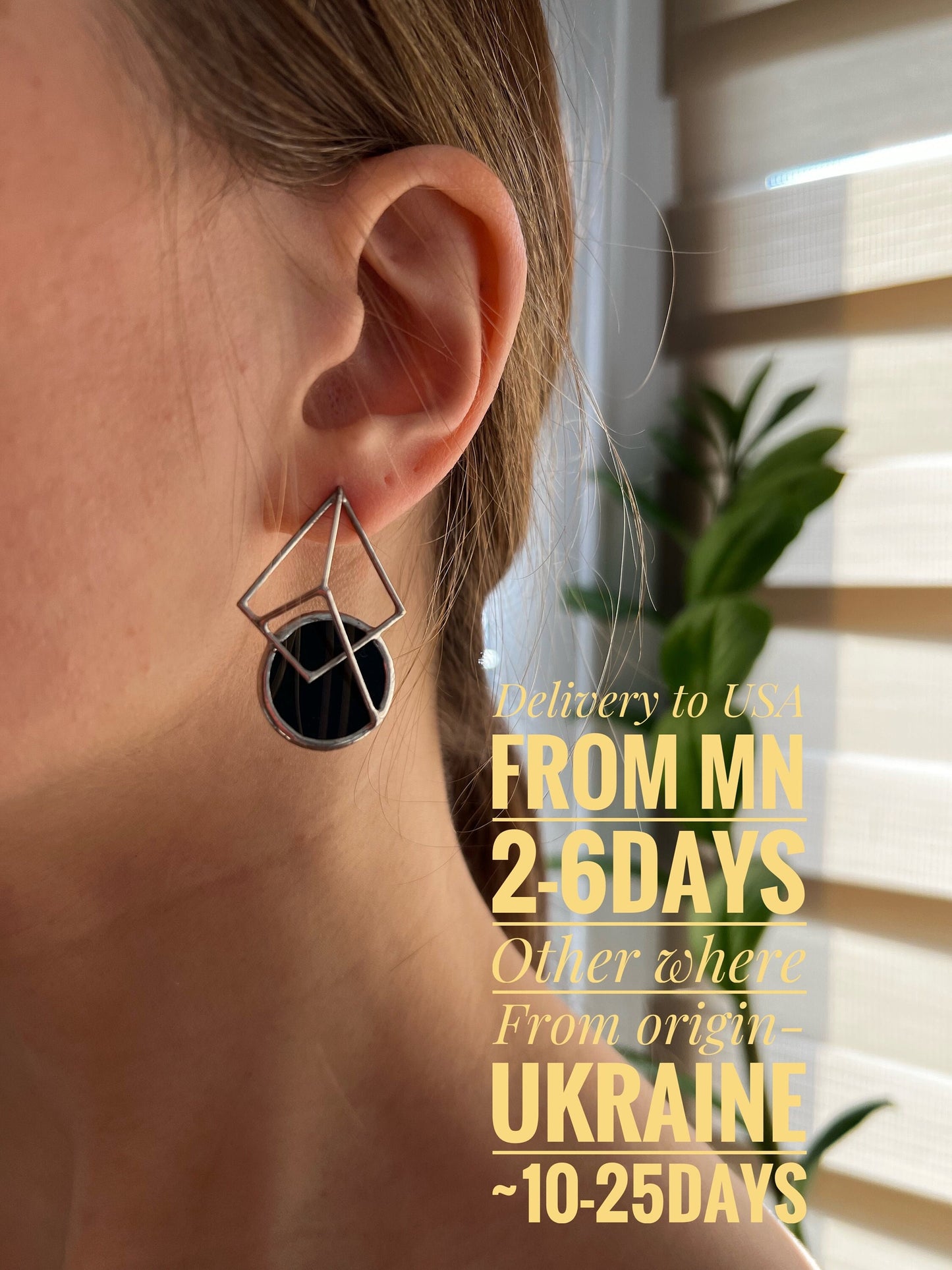 Black glass stud earrings worn by woman close-up