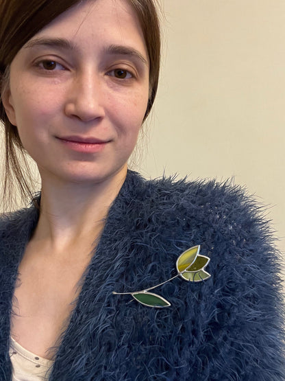 Woman wearing stained glass tulip brooch on sweater botanical statement accessory