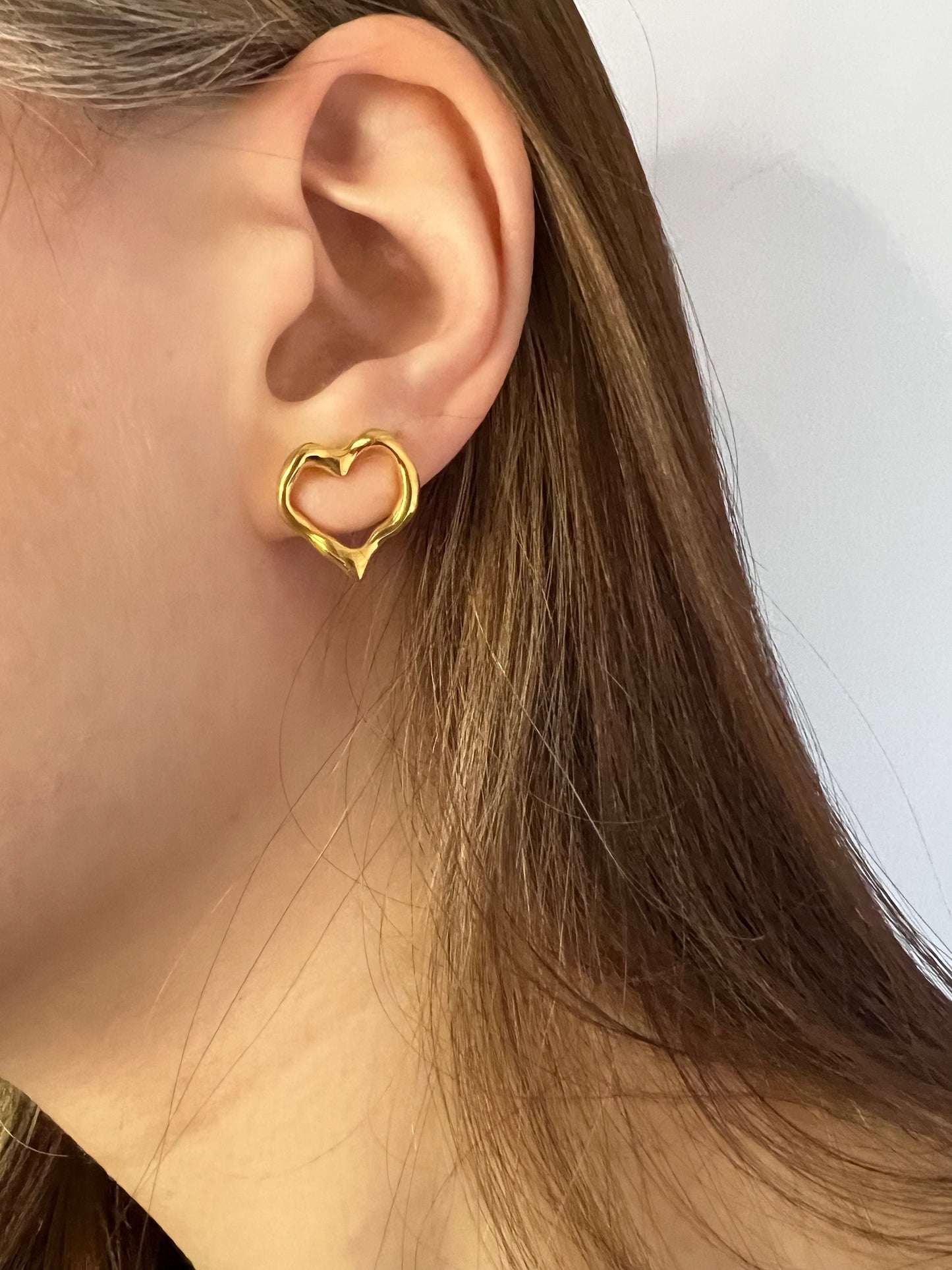 Gold heart hoop earrings side view on ear