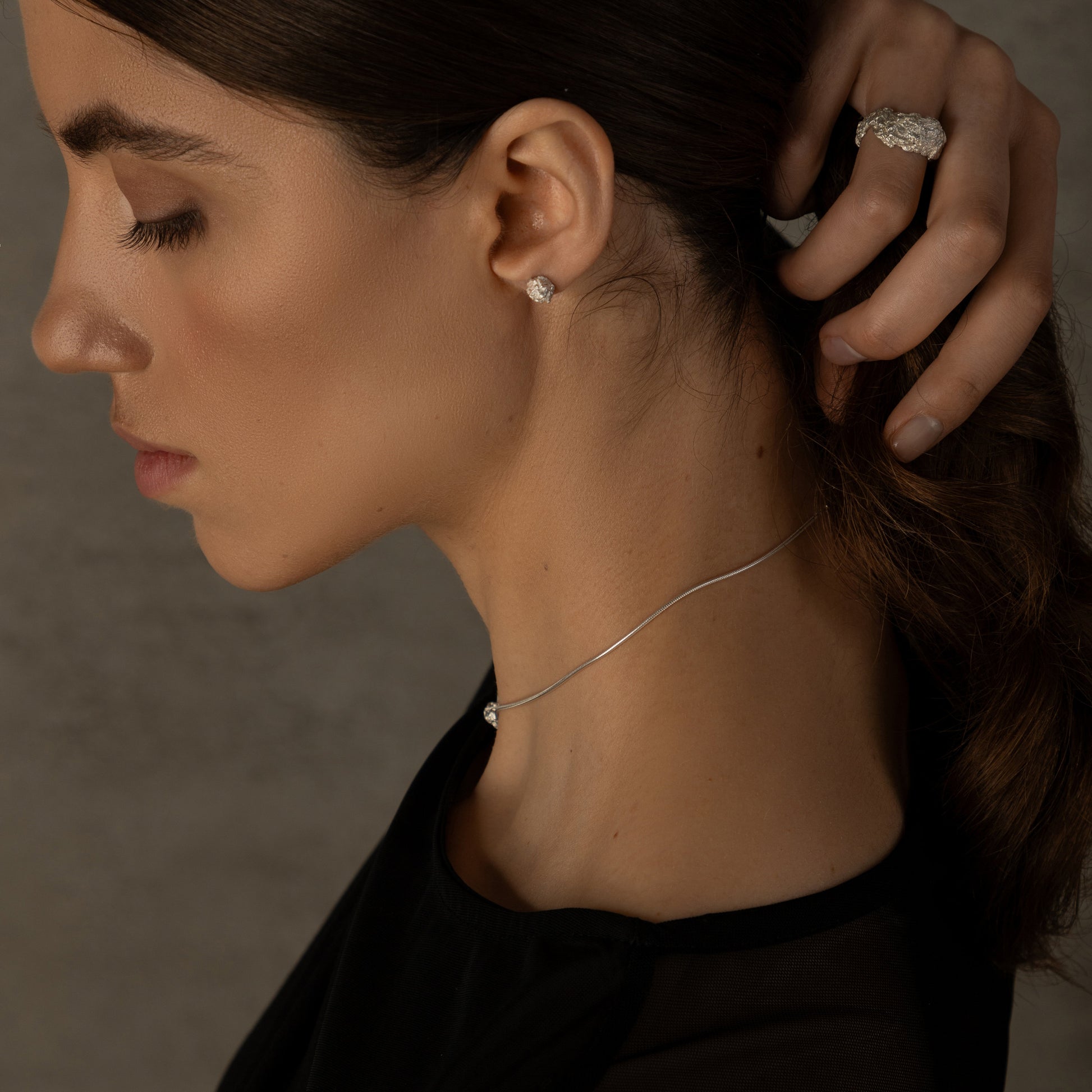 Minimalist silver earrings paired with necklace on model