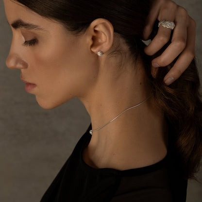 Side view of handmade crumpled silver ring on model