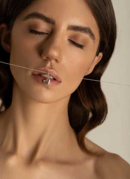 Minimal silver heart necklace worn on model