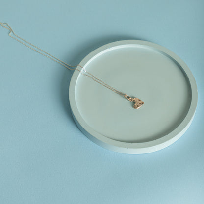 Puffy heart necklace styled on ceramic plate minimal aesthetic