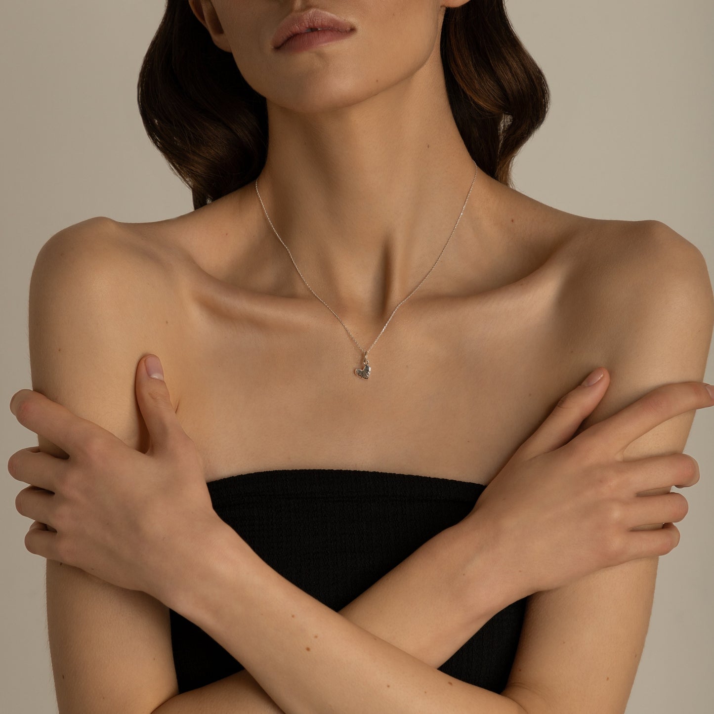 Minimal sterling silver heart necklace on model neck