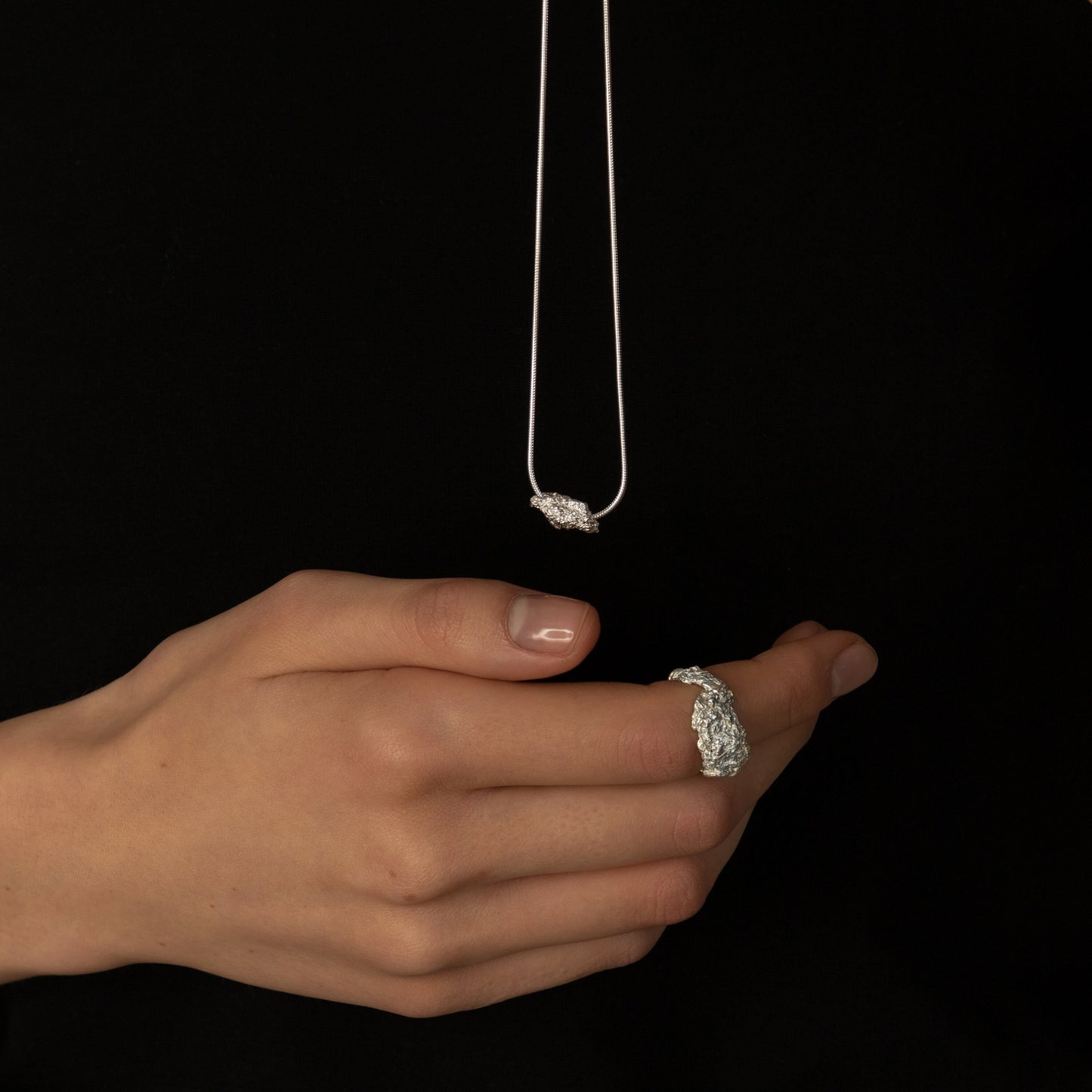 Handcrafted crumpled ring shown on neutral backdrop