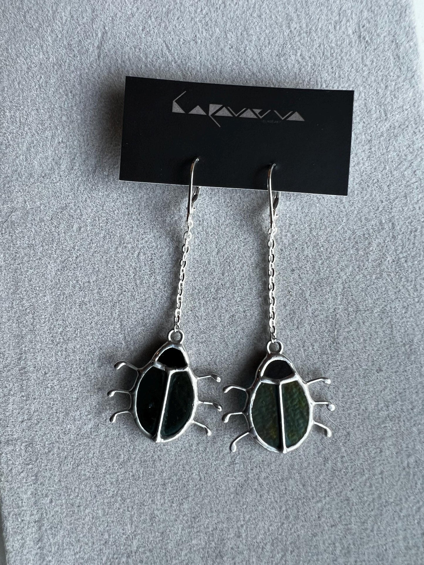 Handmade beetle earrings displayed with branding card, green glass insects