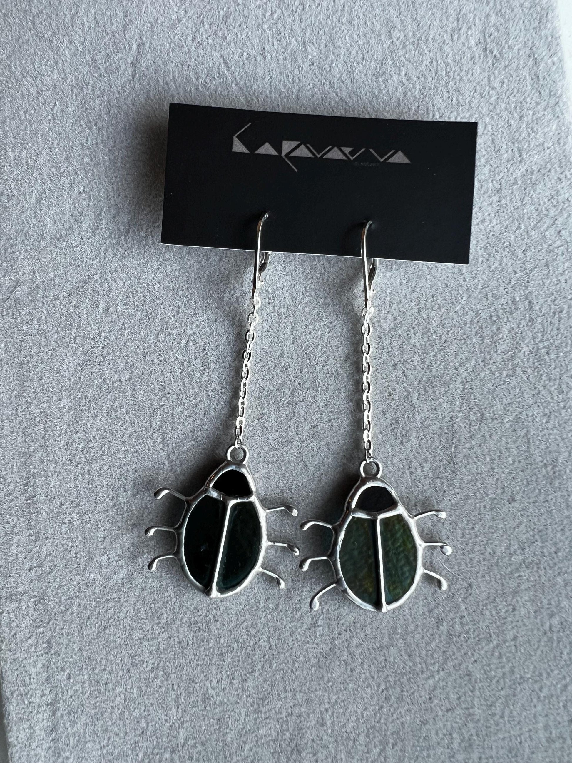 Handmade beetle earrings displayed with branding card, green glass insects