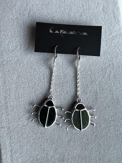 Handmade beetle earrings displayed with branding card, green glass insects