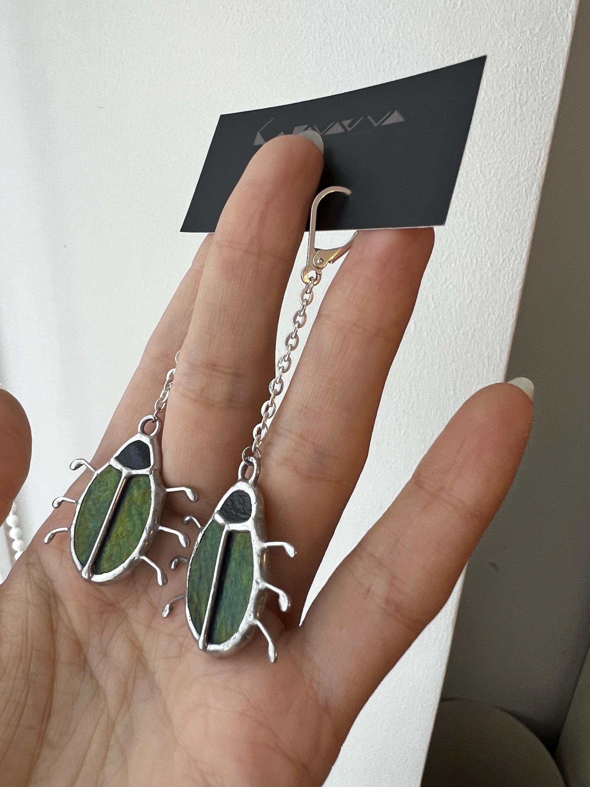 Pair of stained glass bug earrings in deep green with iridescent shine