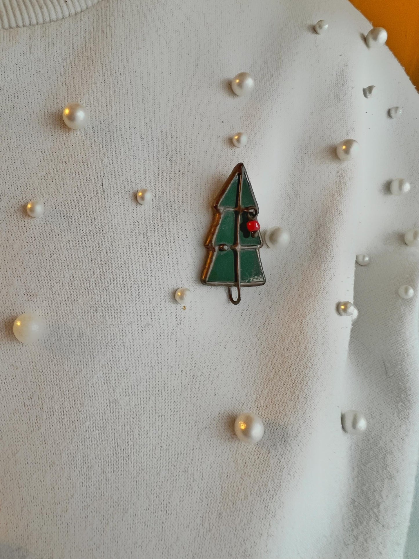 Green Christmas tree stained glass brooch with red decorations on a white background with pearls