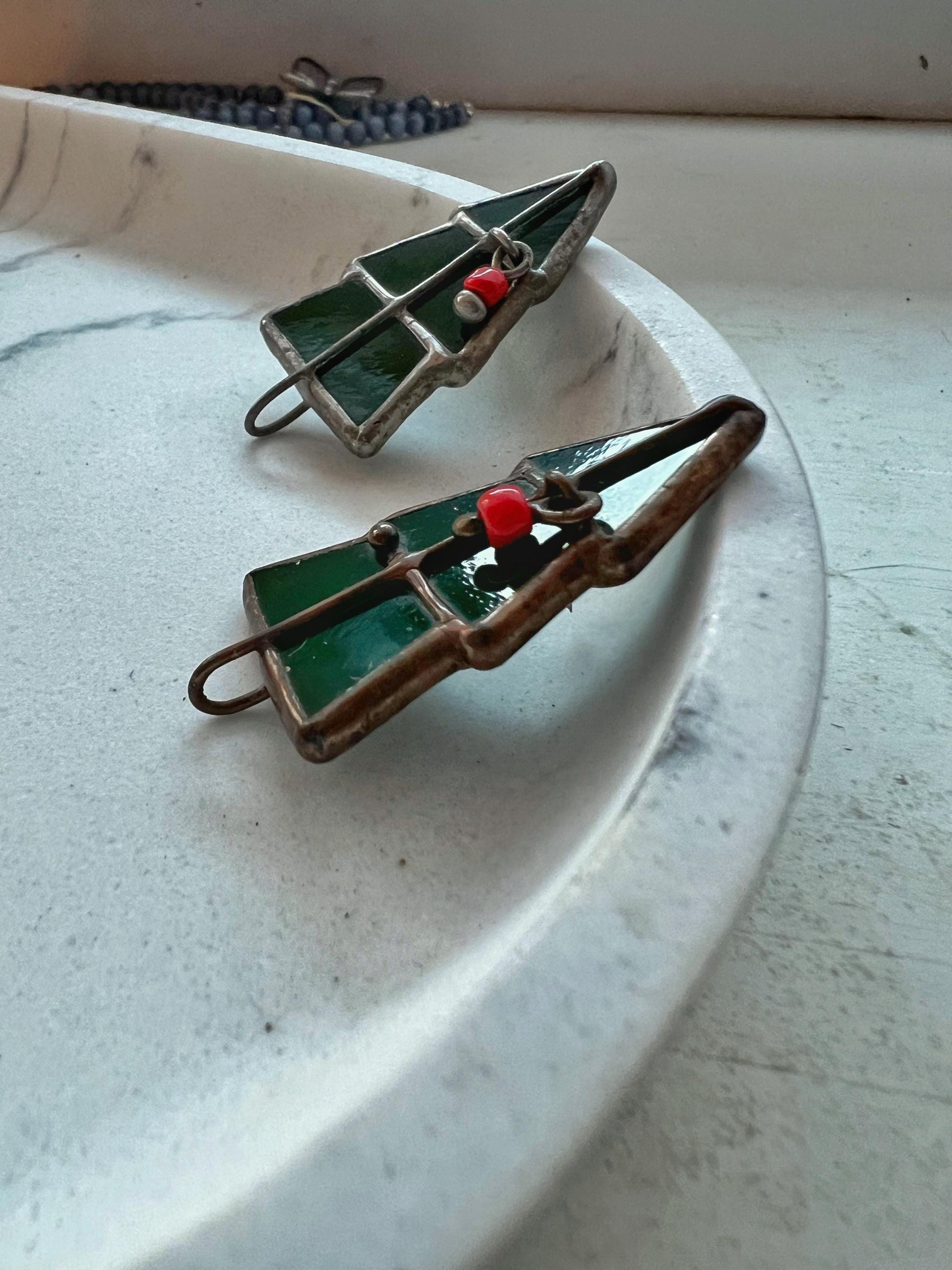 Pair of Christmas tree brooches on a white decorative plate, holiday decor