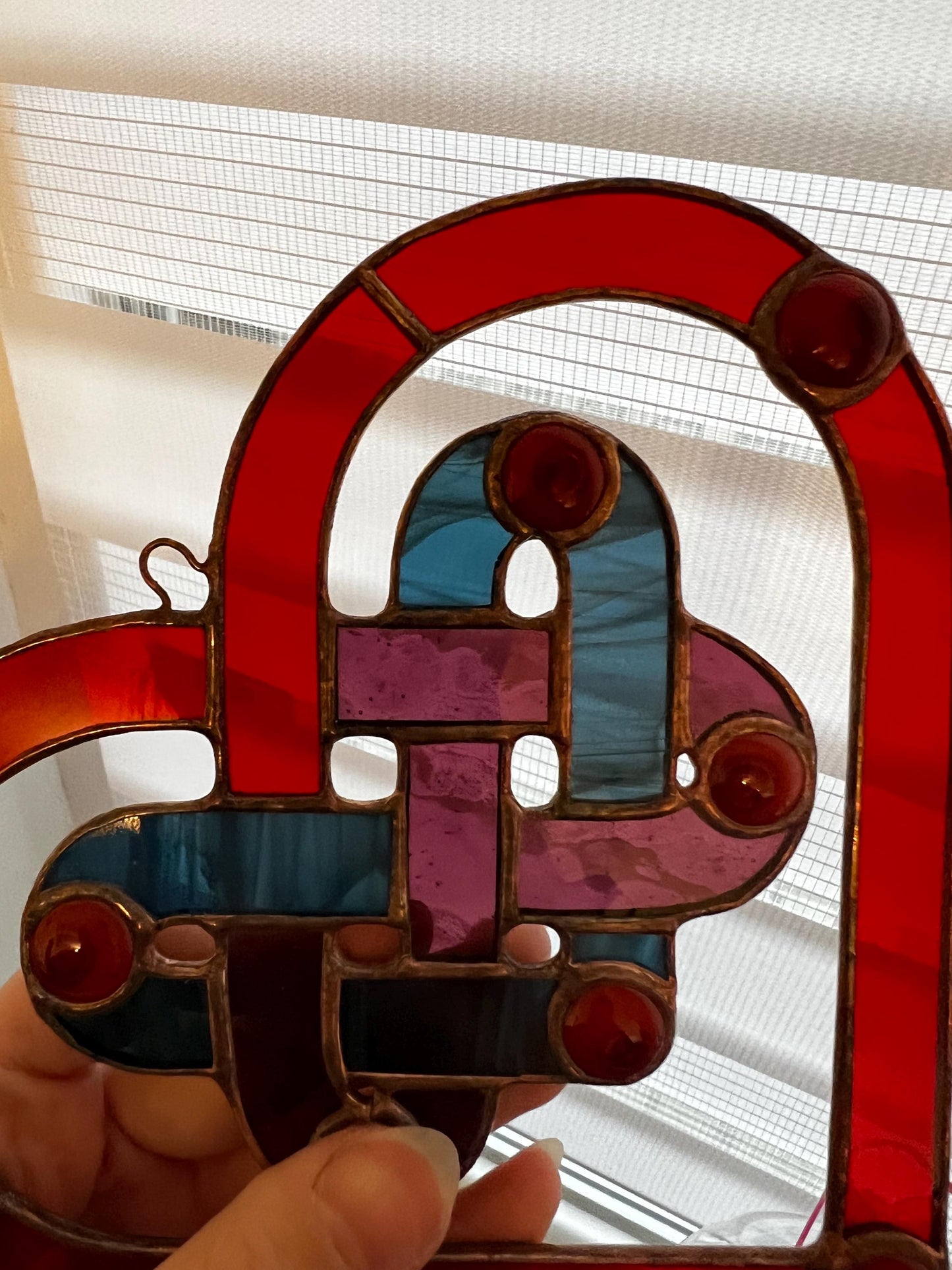 Close up of stained glass heart with woven center