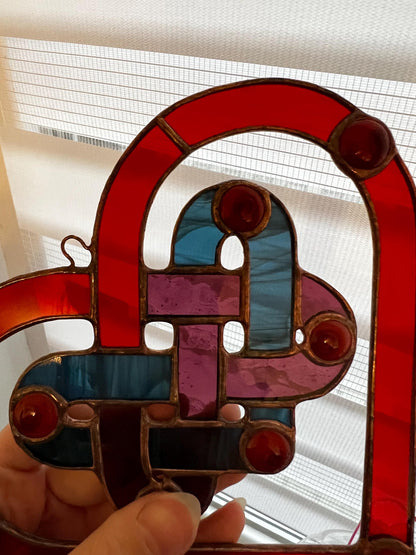 Close up of stained glass heart with woven center