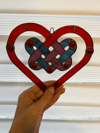 Red stained glass heart suncatcher hanging in window