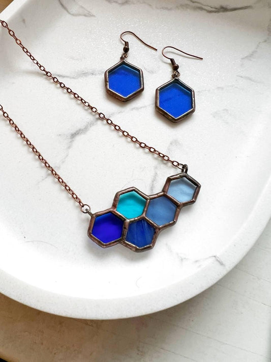 Blue honeycomb stained glass necklace on white background