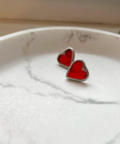 Red heart glass earrings on marble background