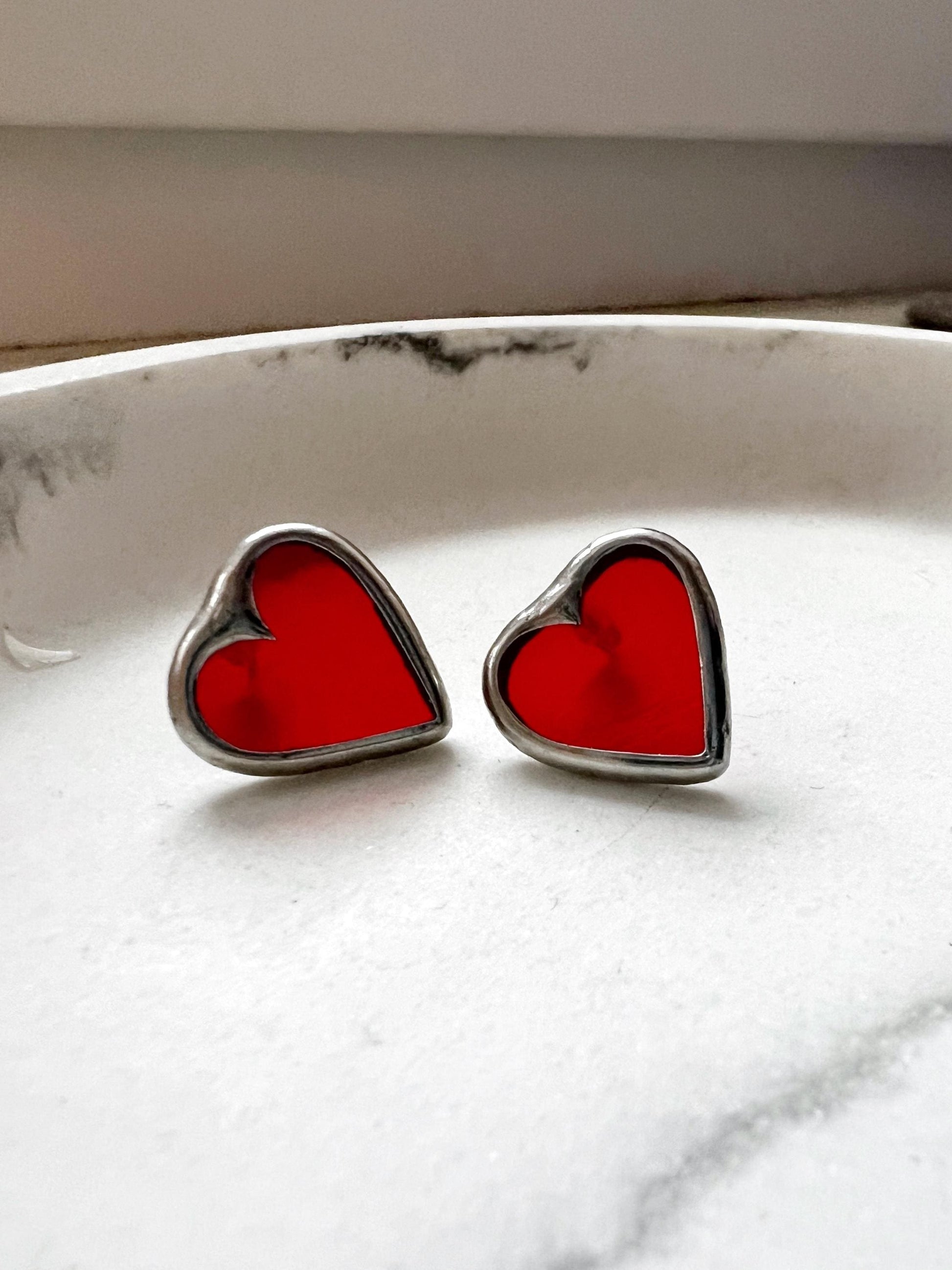 Handmade red stained glass heart earrings on a white surface