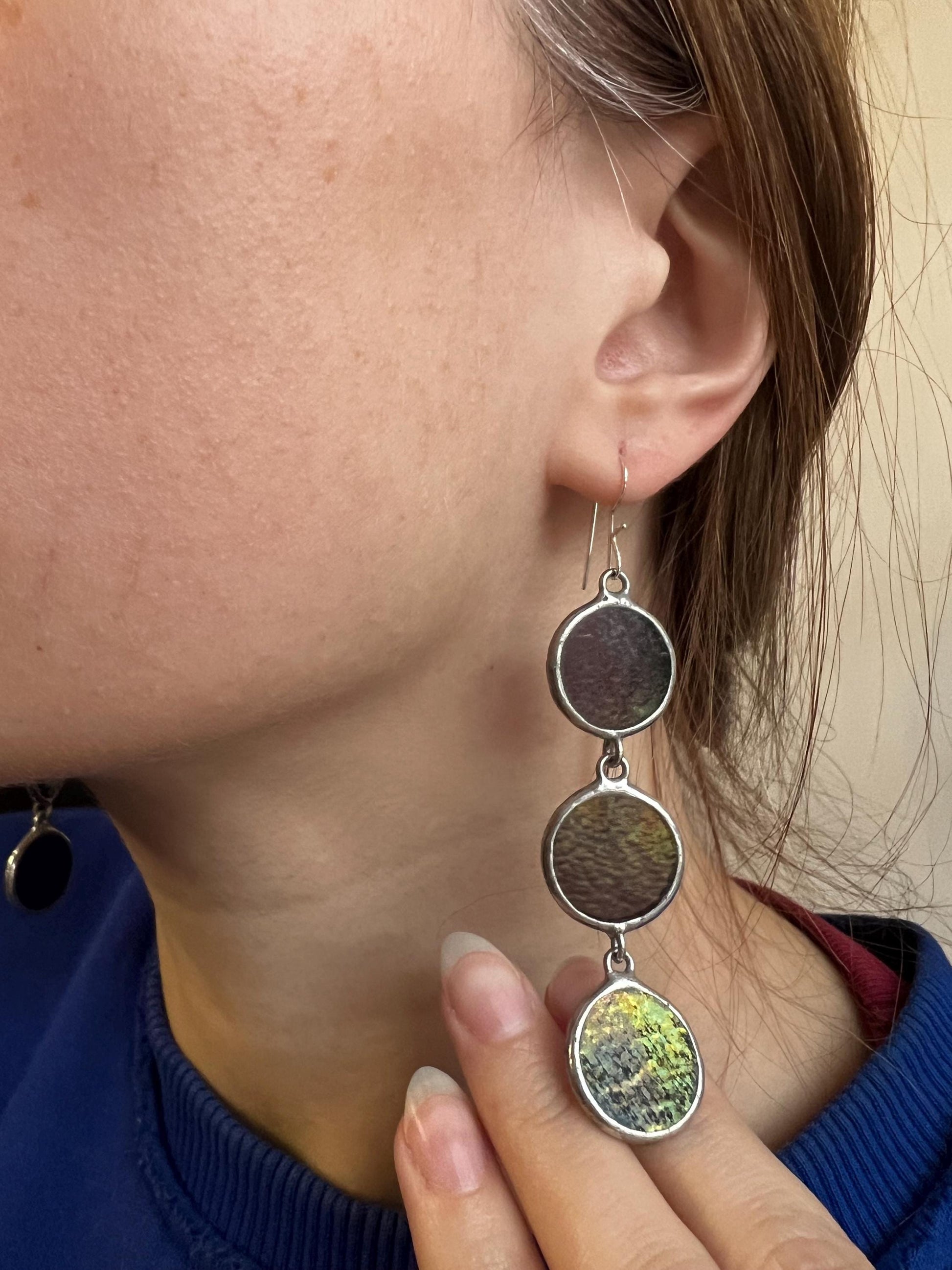 Statement long purple glass earrings worn on ear