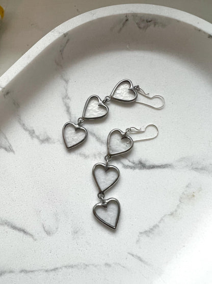 Long stained glass heart earrings on marble background