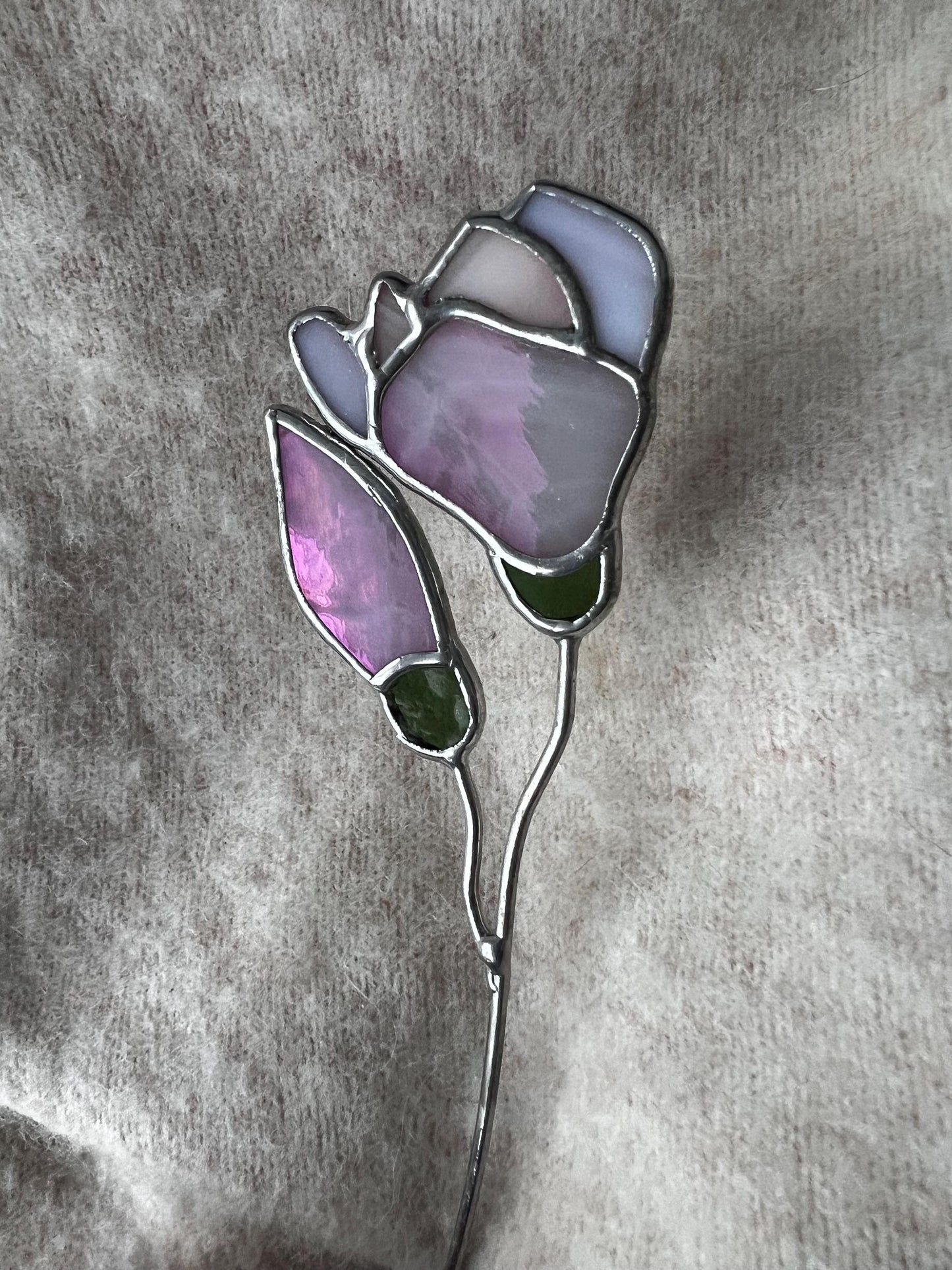 Stained glass magnolia art standing on grey fabric background for product detail view