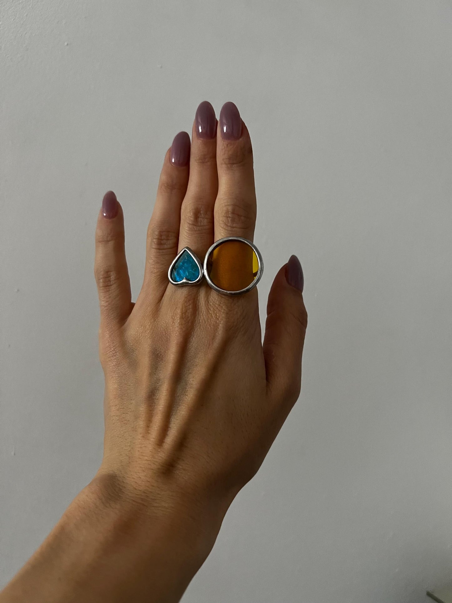 Minimalist heart-shaped stained glass ring worn on hand
