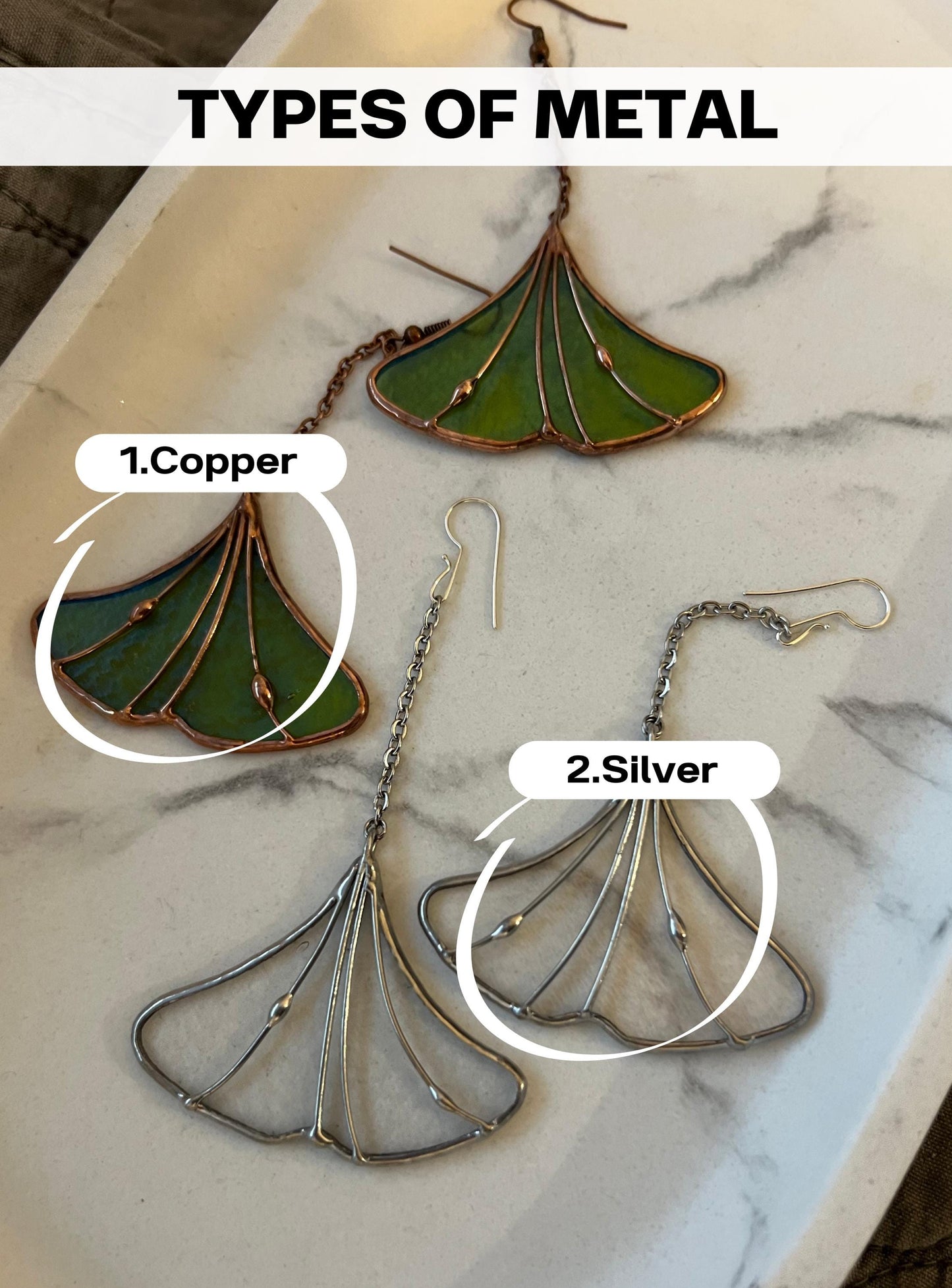 Copper and silver ginkgo leaf stained glass pendants on table