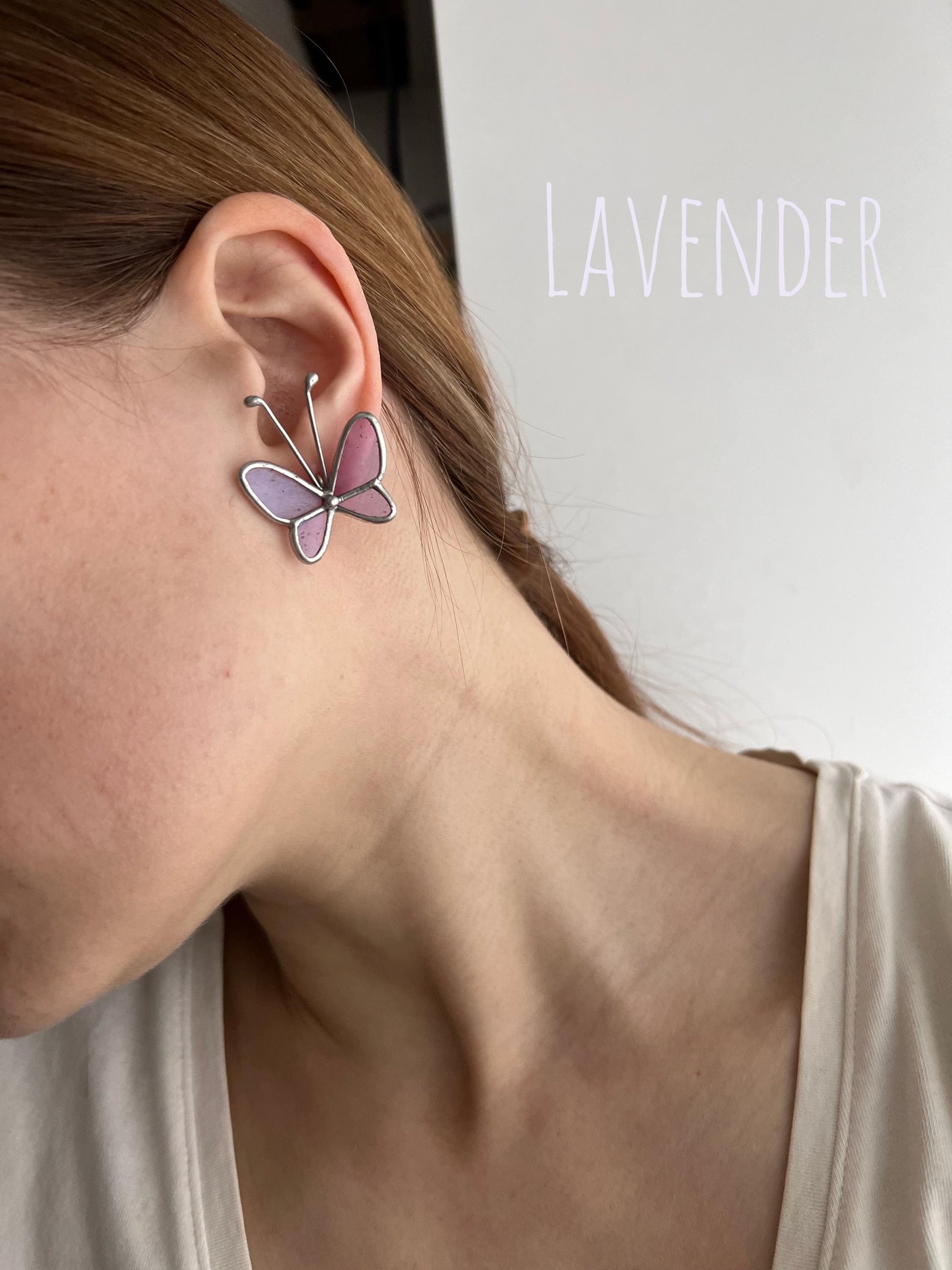 Display of lavender butterfly earrings on ear