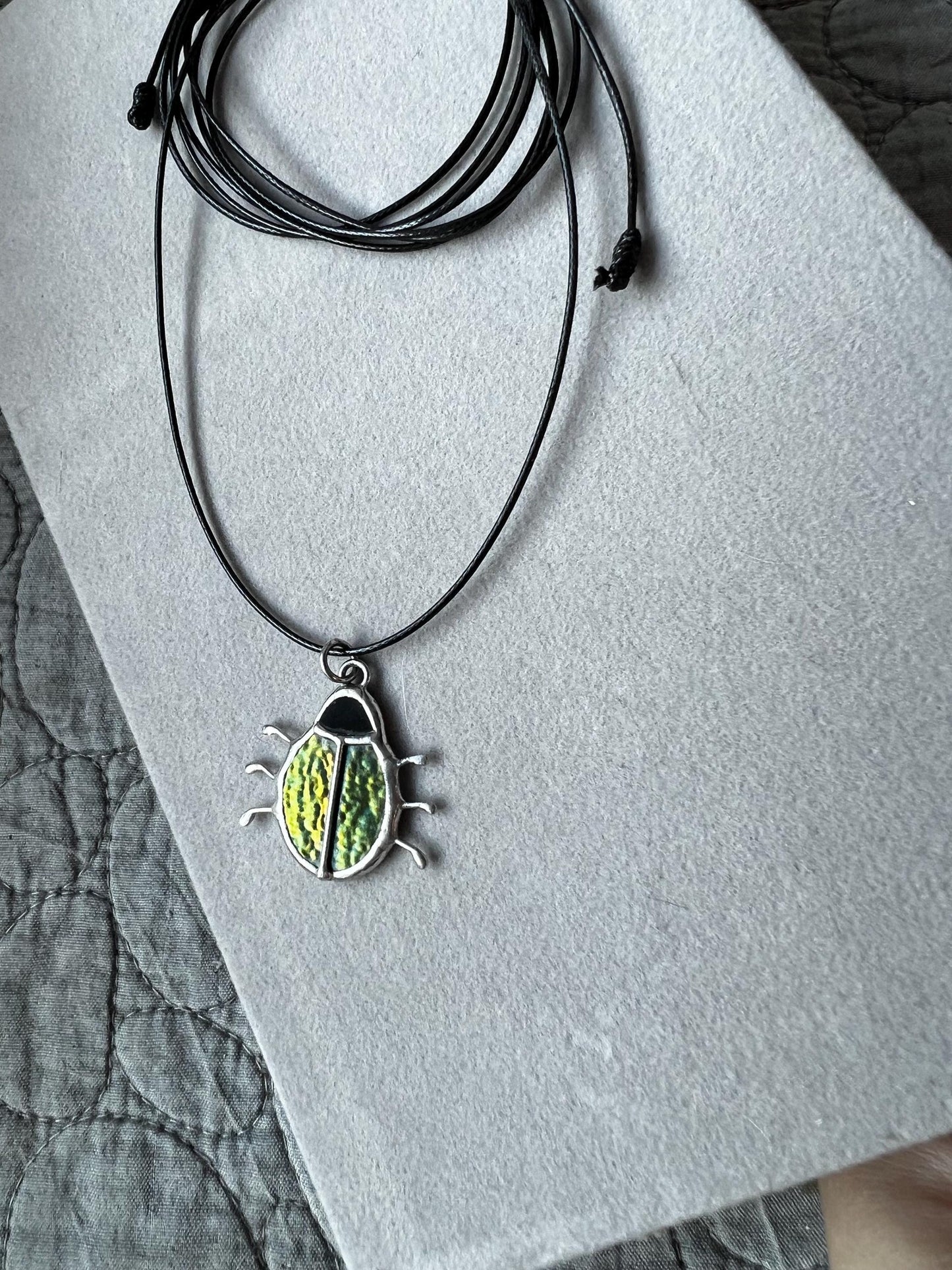 Stained glass beetle pendant on black cord, green iridescent insect jewelry