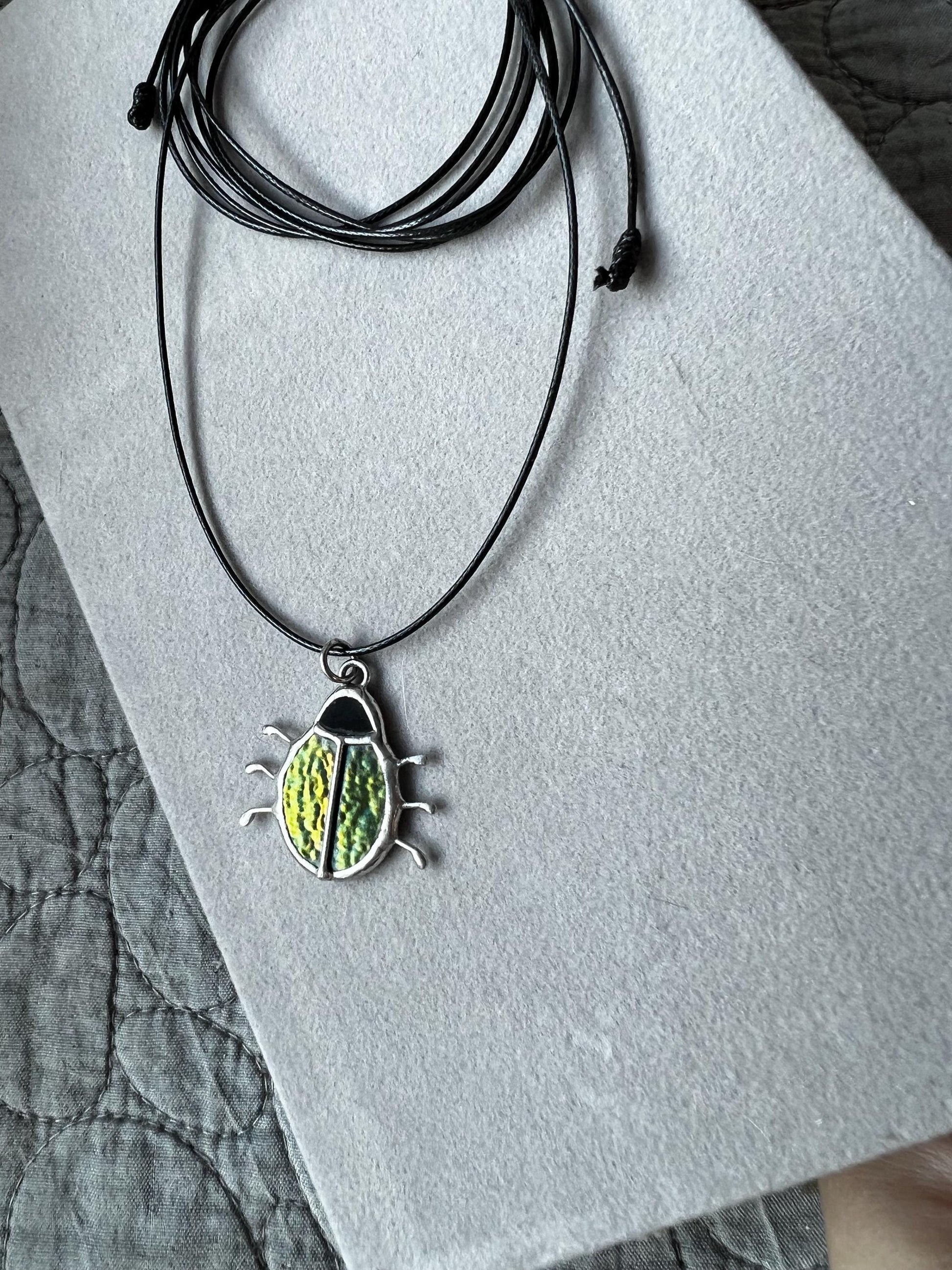 Stained glass beetle pendant on black cord, green iridescent insect jewelry