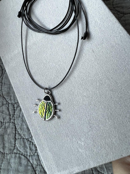 Stained glass beetle pendant on black cord, green iridescent insect jewelry
