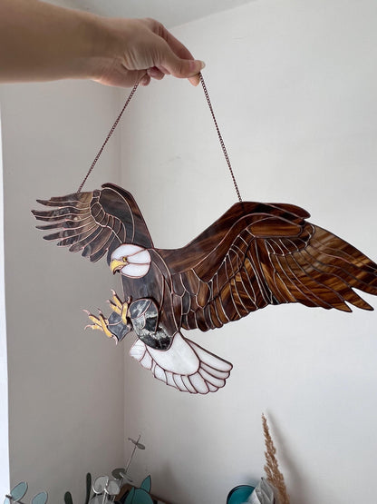 Handmade bald eagle glass suncatcher hanging in window with wings spread