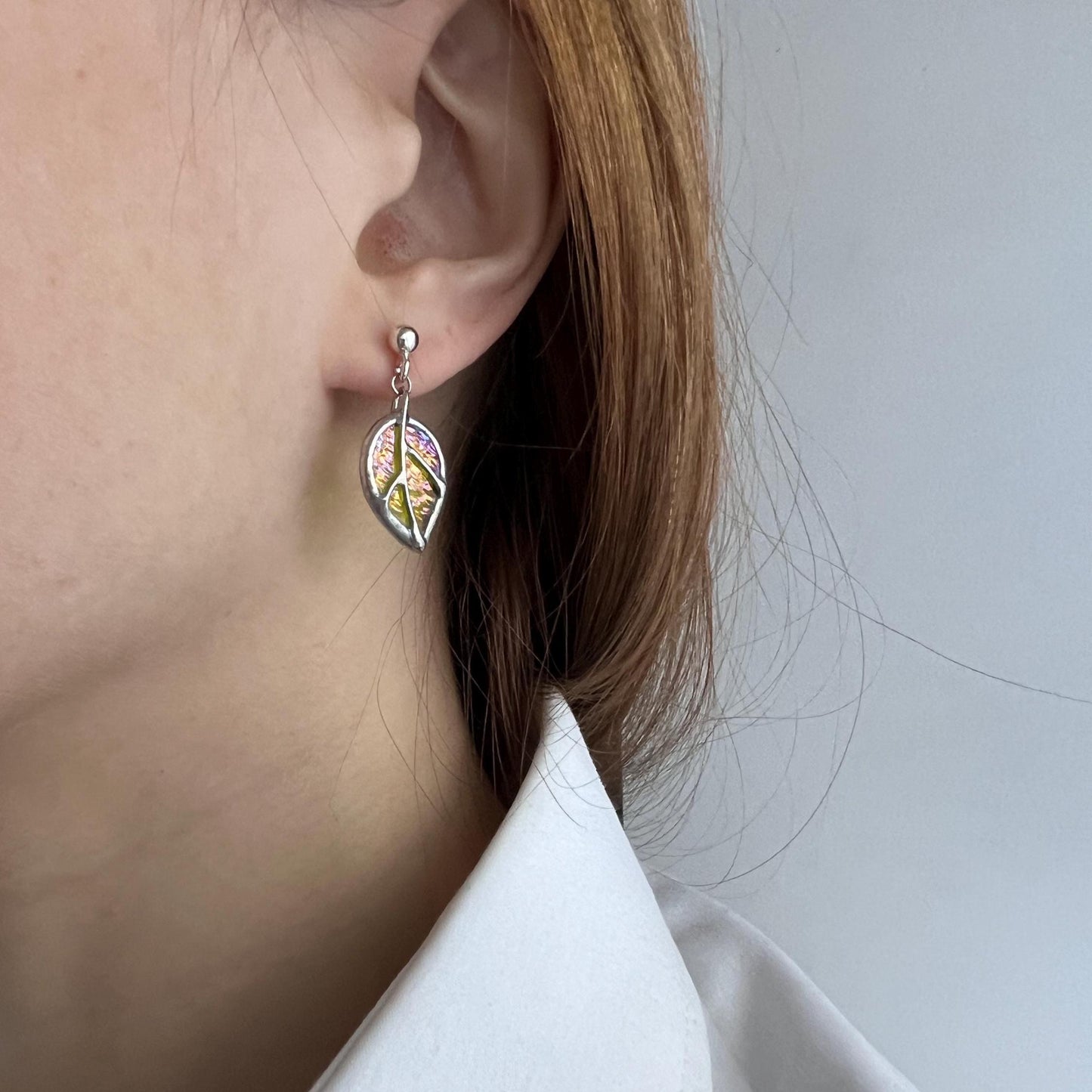 Birch leaf stained glass earrings close-up showing iridescent glass texture