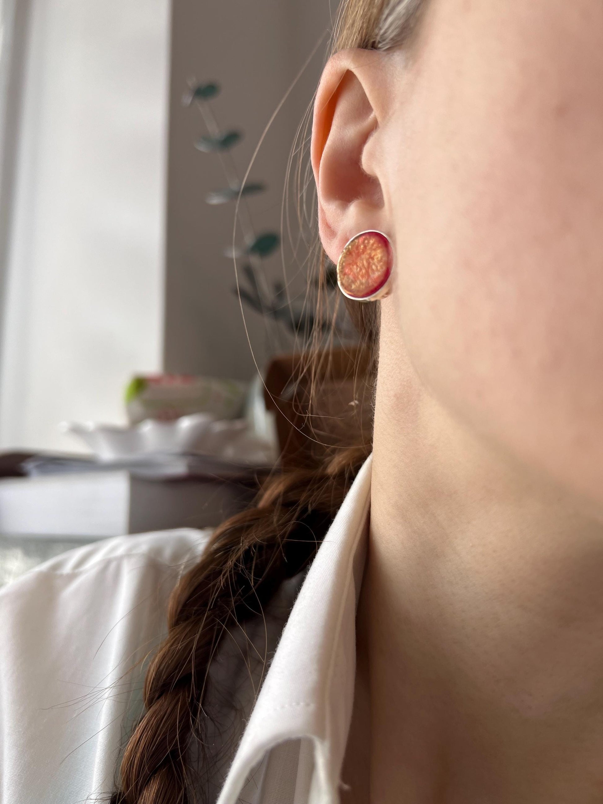 red fused-glass stud earrings worn on ear
