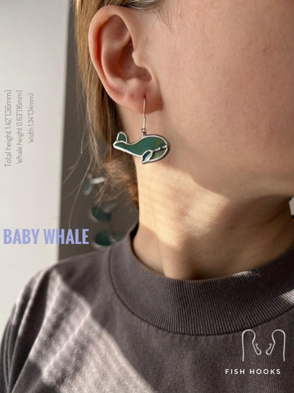 Green stained glass earrings shaped like baby whales. Lightweight handmade ocean-themed dangle earrings.