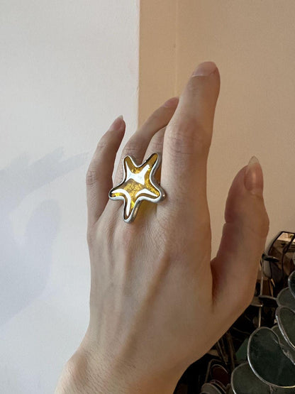 Handmade stained glass ring shaped like a starfish. Ocean-inspired statement jewelry in orange tones.