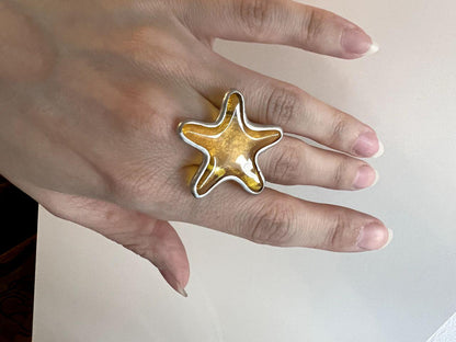 Handmade stained glass ring shaped like a starfish. Ocean-inspired statement jewelry in orange tones.