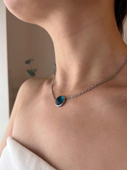 Minimalist turquoise round glass choker on silver chain, handcrafted stained glass jewelry on a neutral background.