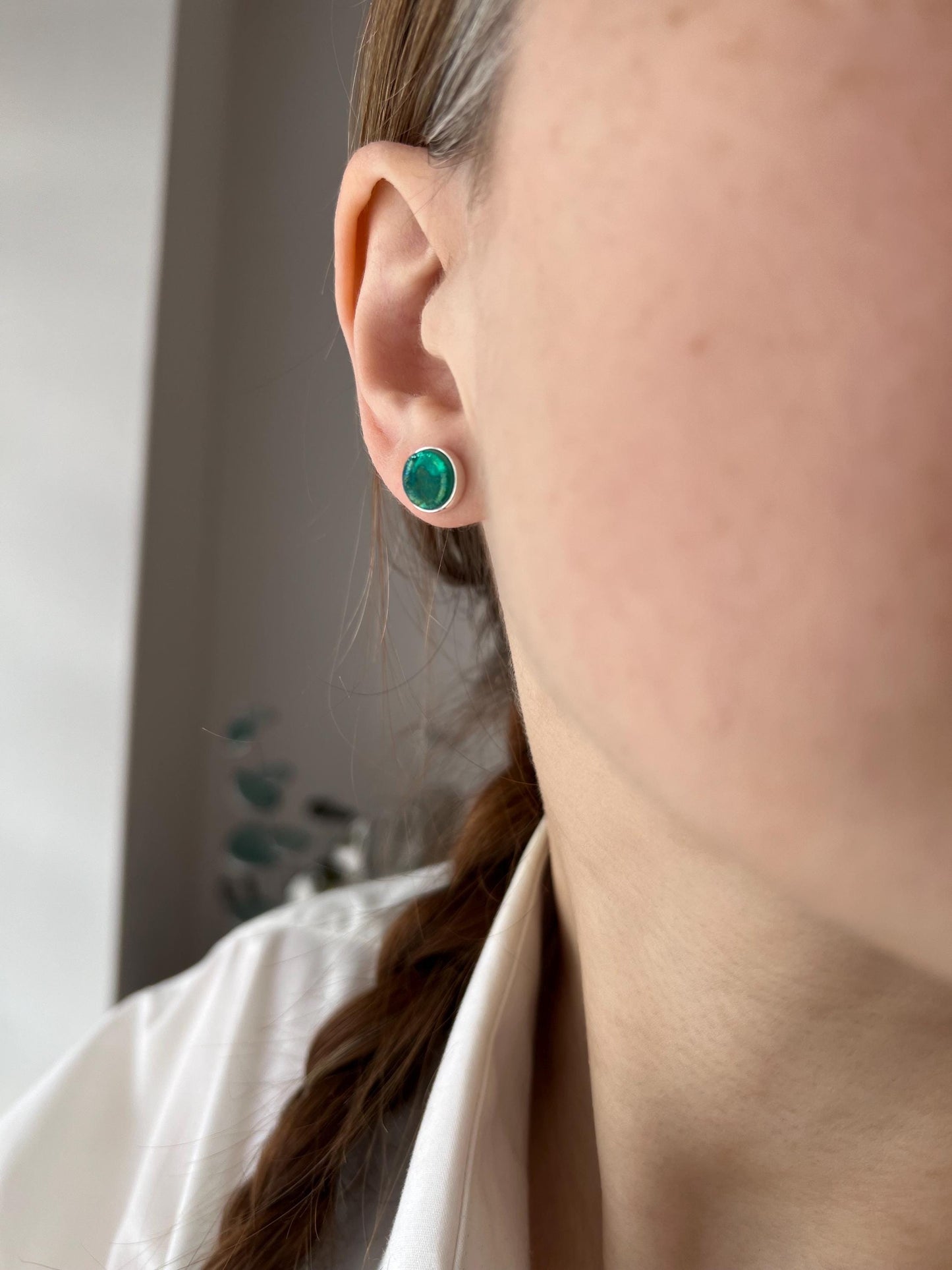 emerald green fused glass stud earrings worn, pearlescent finish