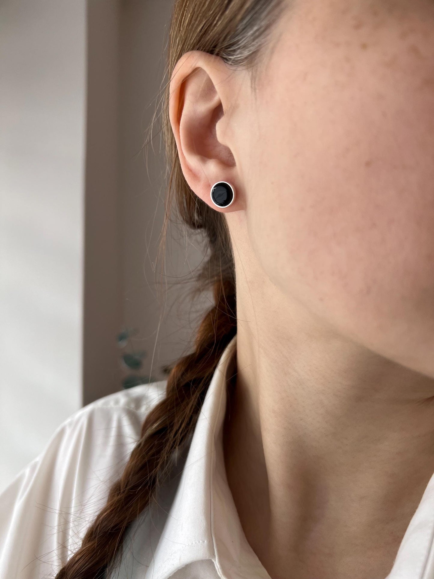 Minimalist round stud earring made of black fused glass with subtle sparkle, mounted on a silver post. Small and modern, perfect for everyday wear.