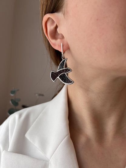 Close-up of a woman wearing handmade stained glass earrings in the shape of a brown bird – lightweight dangle earrings inspired by nature.