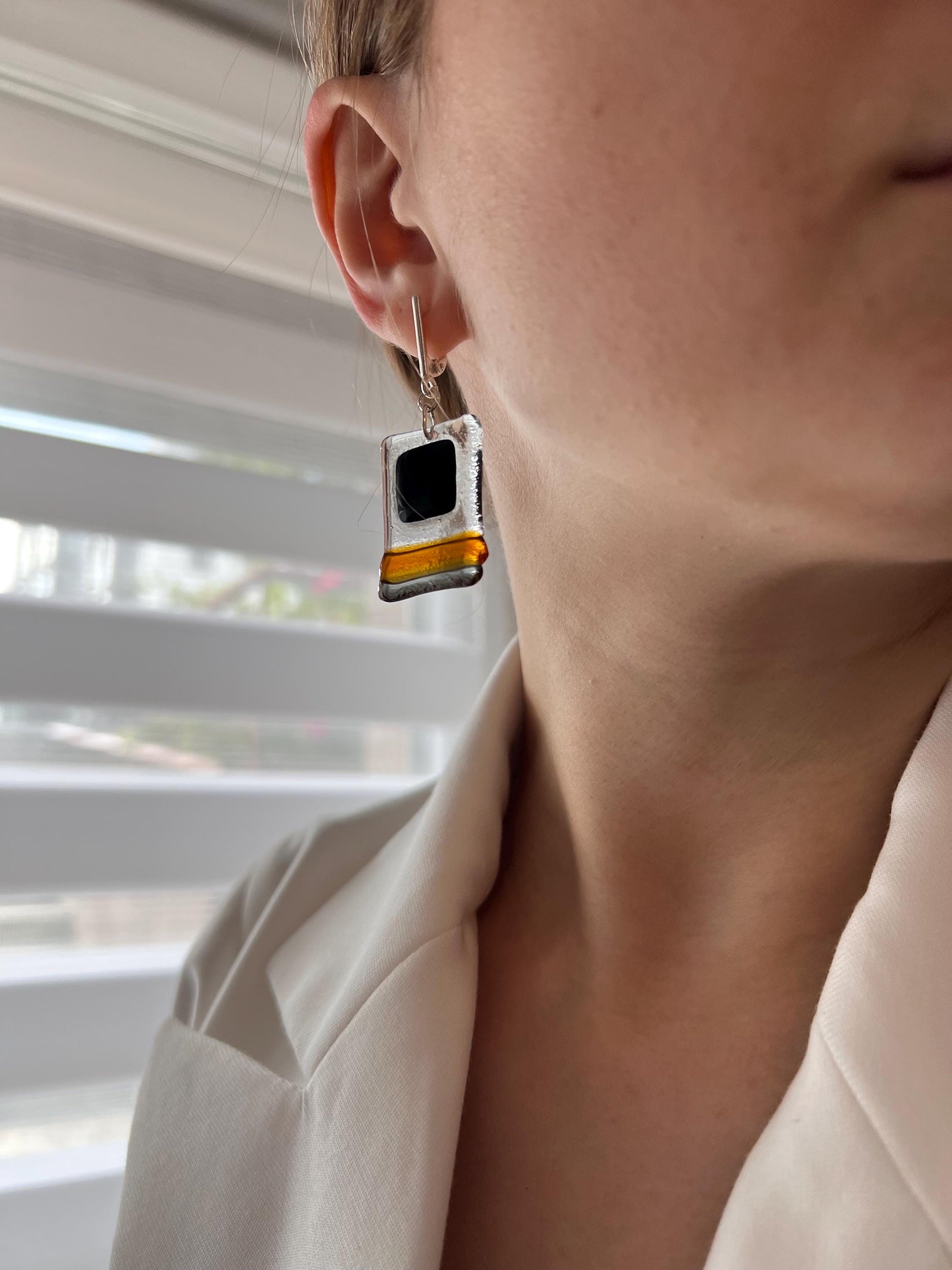 Modern fused glass earrings with sterling silver hooks, featuring geometric rectangular design in contrasting glossy black and amber brown tones
