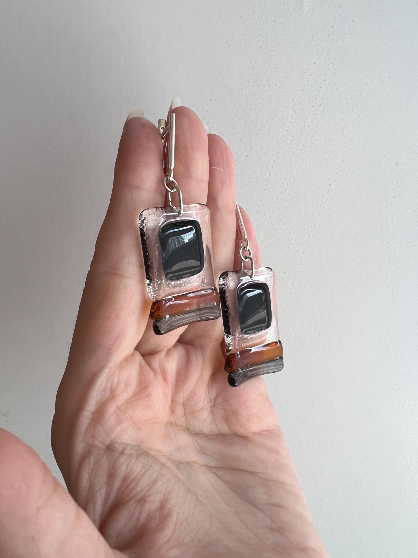 Modern fused glass earrings with sterling silver hooks, featuring geometric rectangular design in contrasting glossy black and amber brown tones
