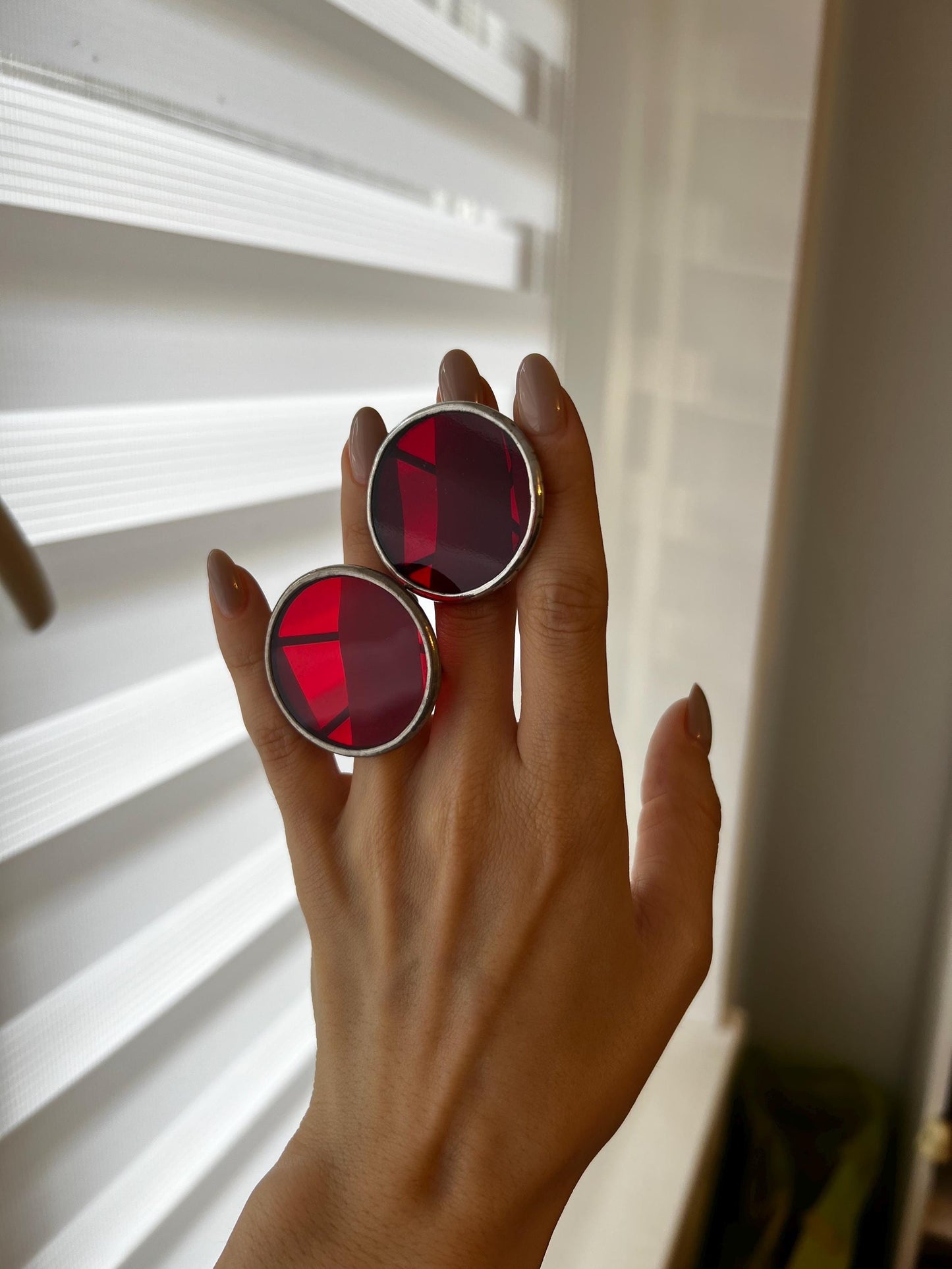 Handmade dark red stained glass ring glowing in natural light, placed on neutral background for a bold and elegant presentation