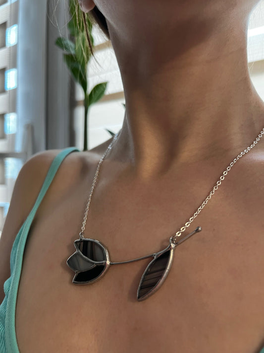 Black stained glass tulip necklace with matching leaf. Handmade floral pendant with bold modern look on silver chain.