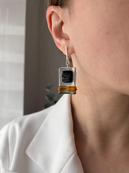 Modern fused glass earrings with sterling silver hooks, featuring geometric rectangular design in contrasting glossy black and amber brown tones