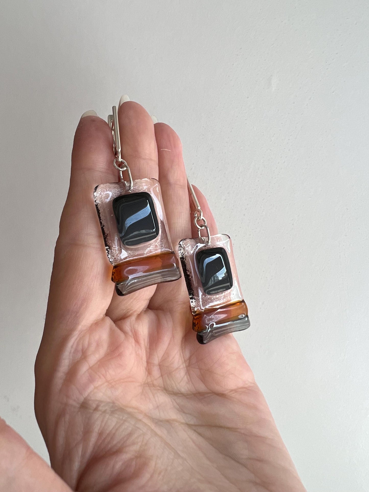 Modern fused glass earrings with sterling silver hooks, featuring geometric rectangular design in contrasting glossy black and amber brown tones