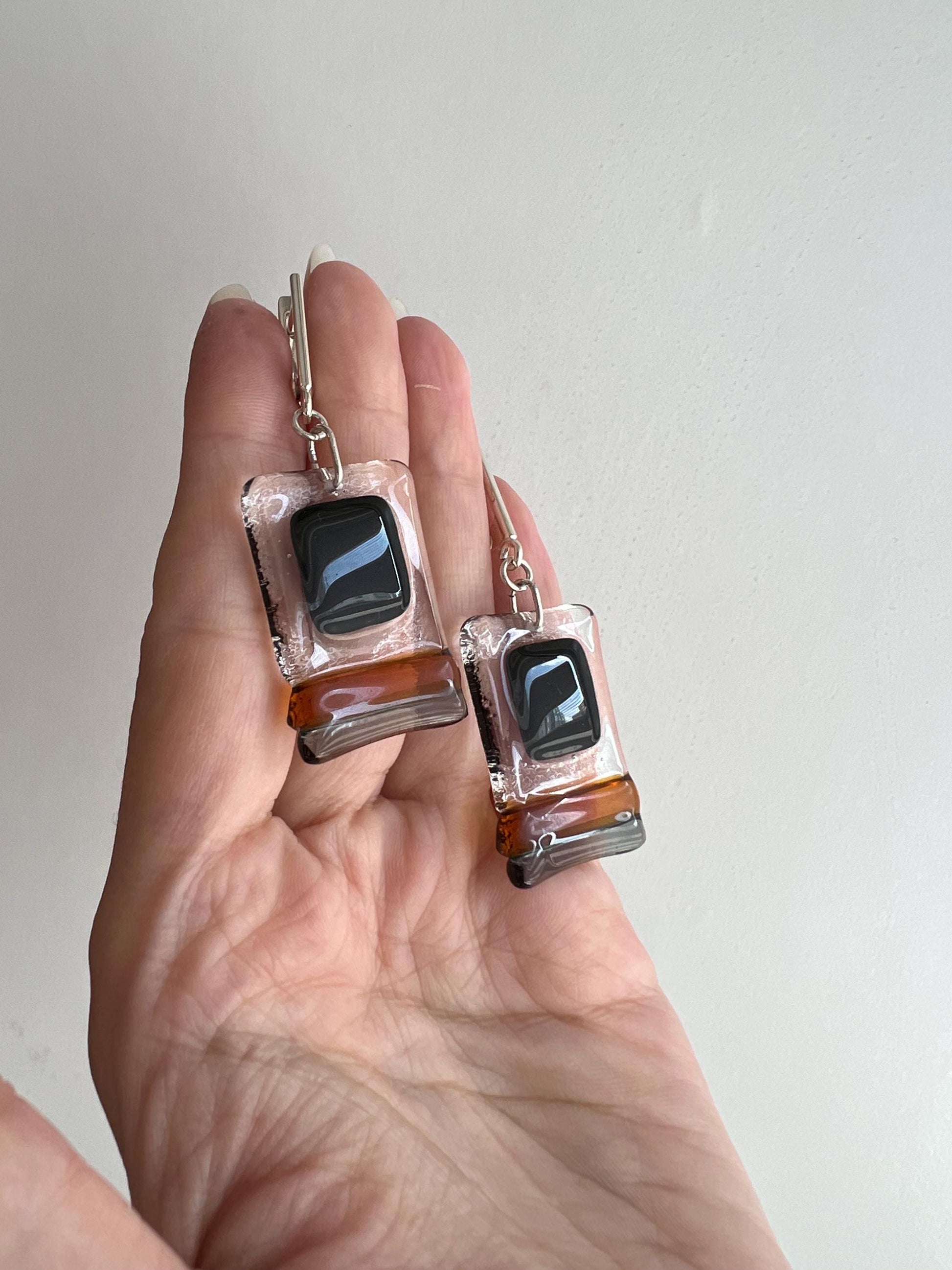 Modern fused glass earrings with sterling silver hooks, featuring geometric rectangular design in contrasting glossy black and amber brown tones