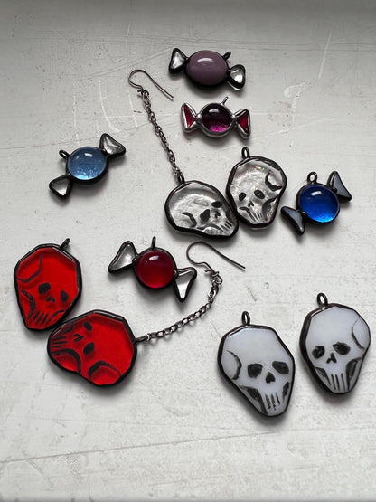 Handmade stained glass skull earrings in red, white, and clear