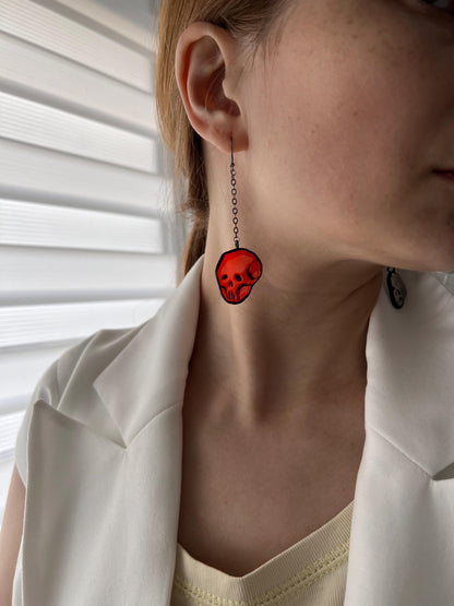 Handmade skull earring catching the light, spooky shadows