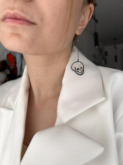 Minimalist skull earring styled with white blazer gothic contrast